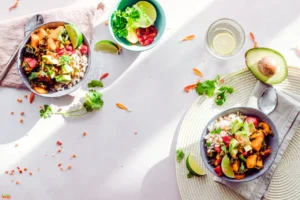 How Can Diet Affect Healthy Eyesight? Find Out! A vibrant overhead view of nutrient-rich bowls featuring sweet potatoes, leafy greens, and citrus—essential foods for maintaining healthy eyesight.