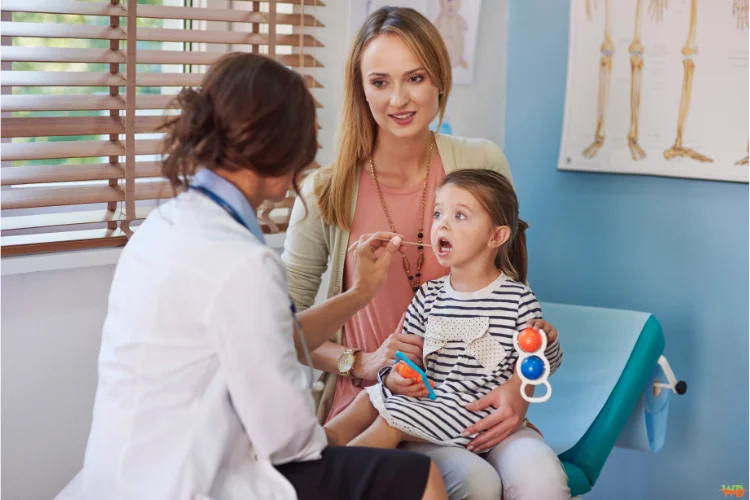 A doctor attending to an elderly patient alongside another doctor talking to a young mother with her child