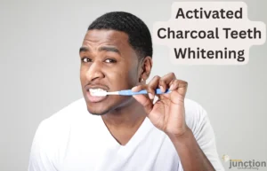 Close-up of a person brushing their teeth with activated charcoal powder on the toothbrush bristles.