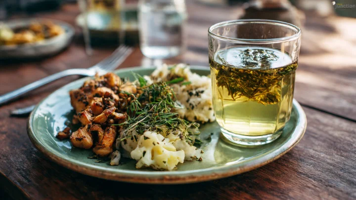 Soutaipasu meal pairing showing herb-seasoned food with herbal infused tea on a rustic wooden table.
