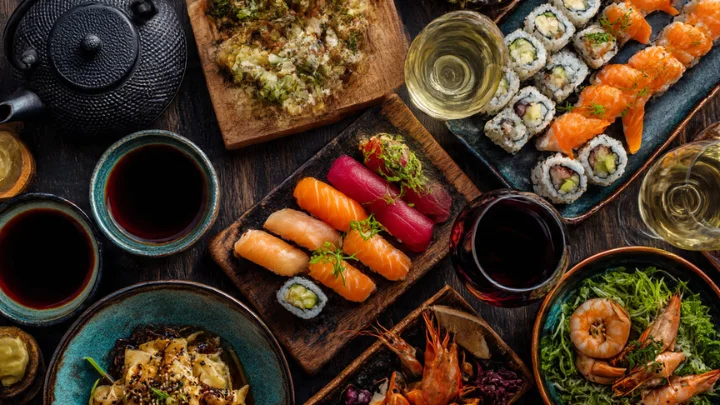 Soutaipasu cultural food and drink pairing featuring sushi, seafood, wine, and tea on a shared dining table.