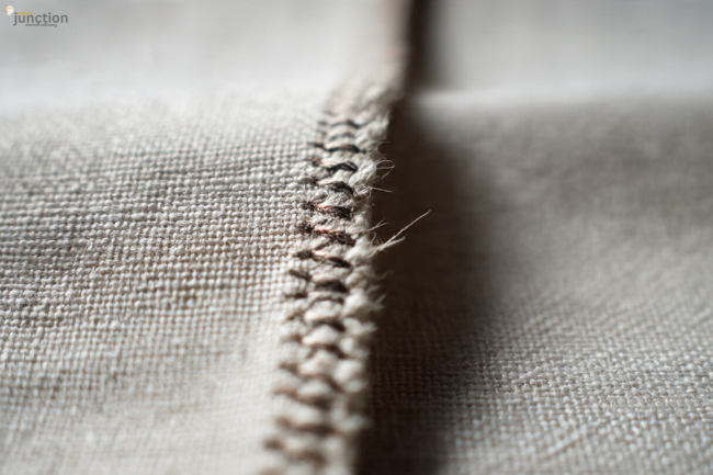 Close-up of a fabric seam with visible stitches and frayed edges, illustrating Nahttypen used in sewing and garment construction.