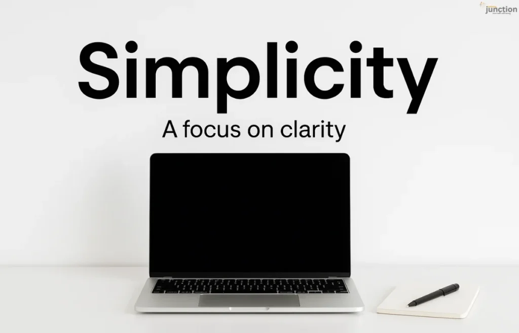 Simplicity in a minimal workspace featuring a laptop, coffee mug, and notebook on a clean white desk, illustrating clarity and focus.